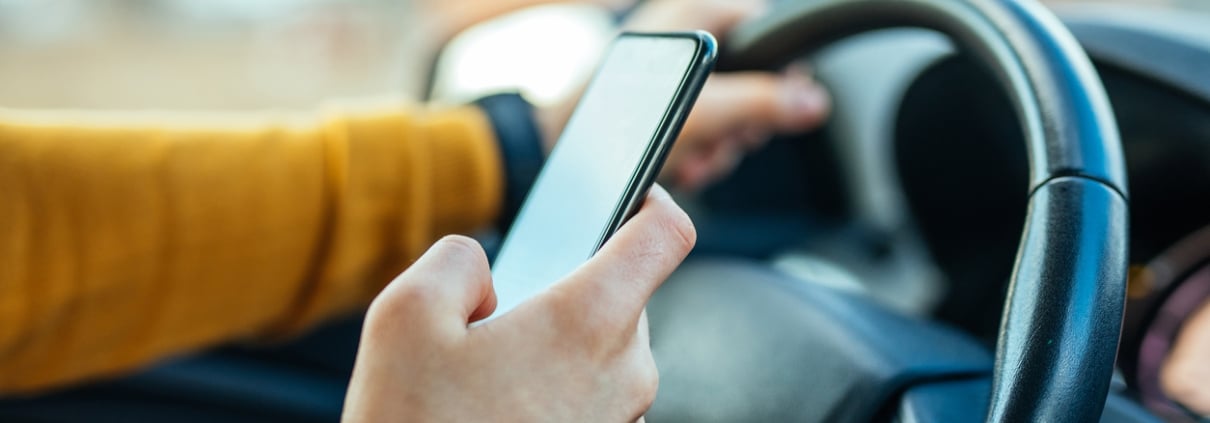 Shot of a male using mobile phone while driving the car.