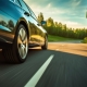 Low angle side view of car rushes along the highway at sunset