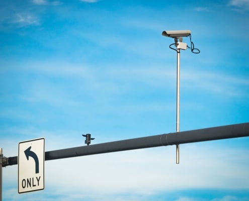 Traffic security camera mounted on intersection traffic light post.