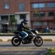 Motorcyclist with a helmet on an avenue in the Colombian capital in the evening light.