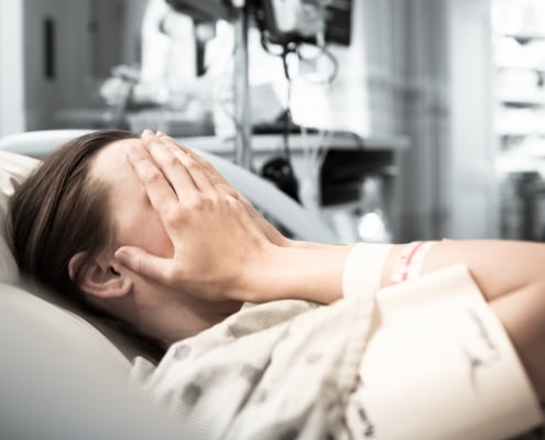 Young woman patient lying at hospital bed feeling sad and depressed worried. Disease feeling sick in health care and clinical attention concept