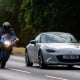 Man riding a Suzuki motorcycle overtakes a Mazda MX5 car on the A5