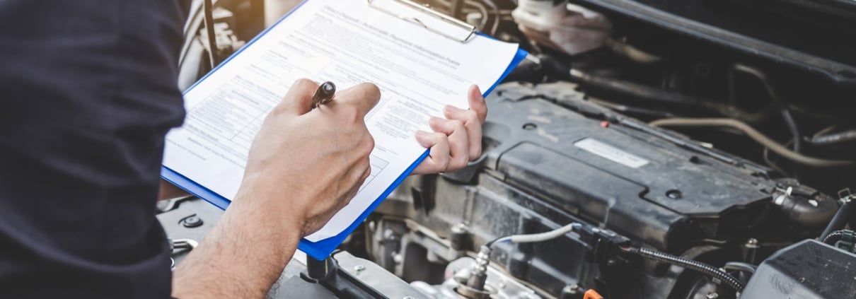 Services car engine machine concept, Automobile mechanic repairman checking a car engine with inspecting writing to the clipboard the checklist for repair machine, car service and maintenance.