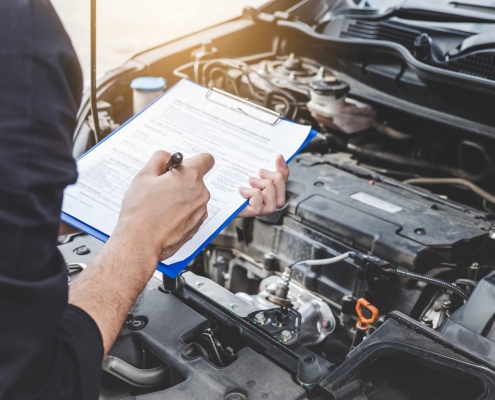 Services car engine machine concept, Automobile mechanic repairman checking a car engine with inspecting writing to the clipboard the checklist for repair machine, car service and maintenance.