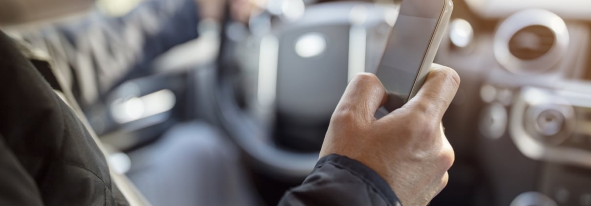 Using a phone in a car texting while driving concept for danger of text message and being distracted