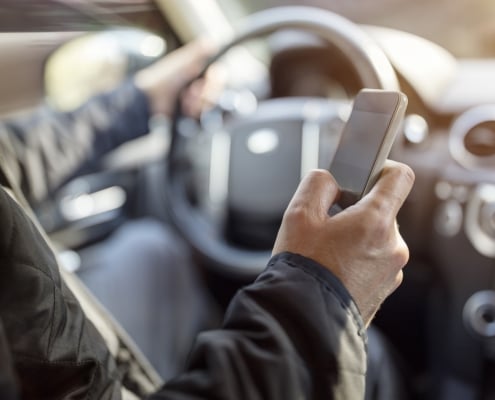 Using a phone in a car texting while driving concept for danger of text message and being distracted