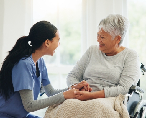 Happy woman, doctor and senior patient in wheelchair, support or trust for healthcare advice at old age home. Medical nurse, caregiver or person with a disability smile for care or help at house