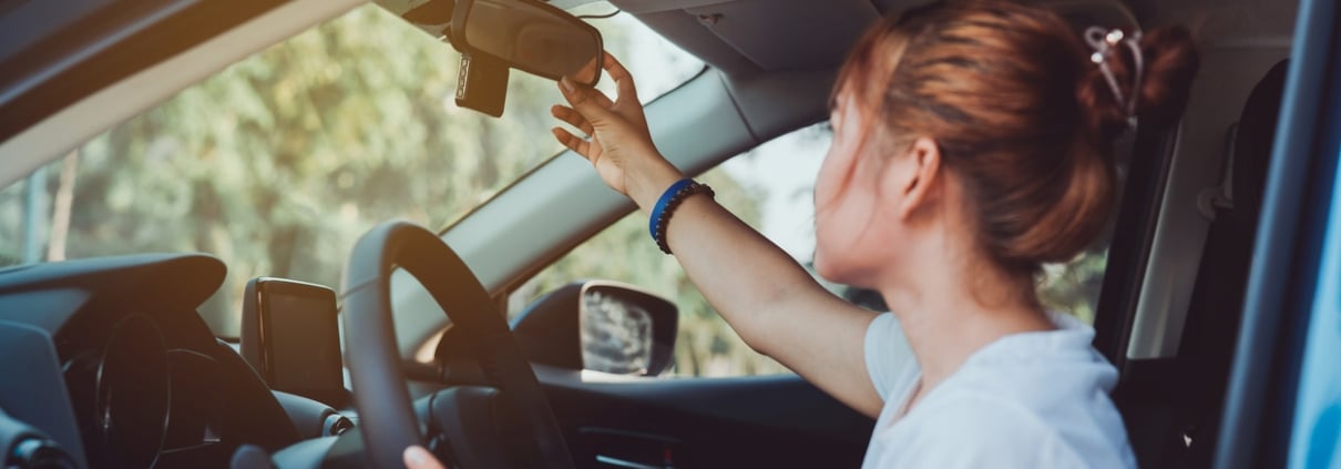 Safety driving woman adjust the car rearview mirror in interior before start travel trip every time.