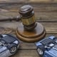 hammer of the judge. two collapsed inverted car on a wooden background.