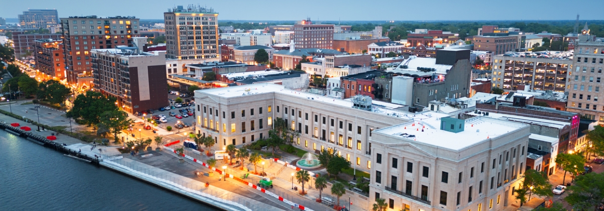 Wilmington, North Carolina, USA cityscape over the Cape Fear and Wilmington Riverwalk at dusk.