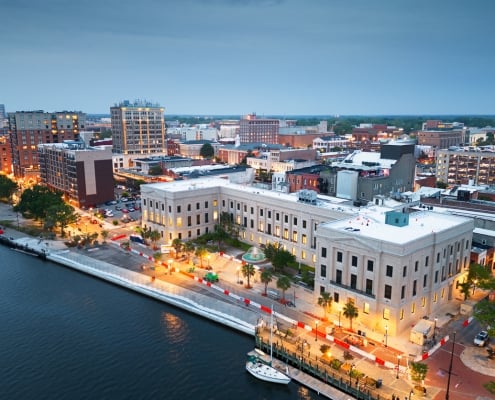 Wilmington, North Carolina, USA cityscape over the Cape Fear and Wilmington Riverwalk at dusk.