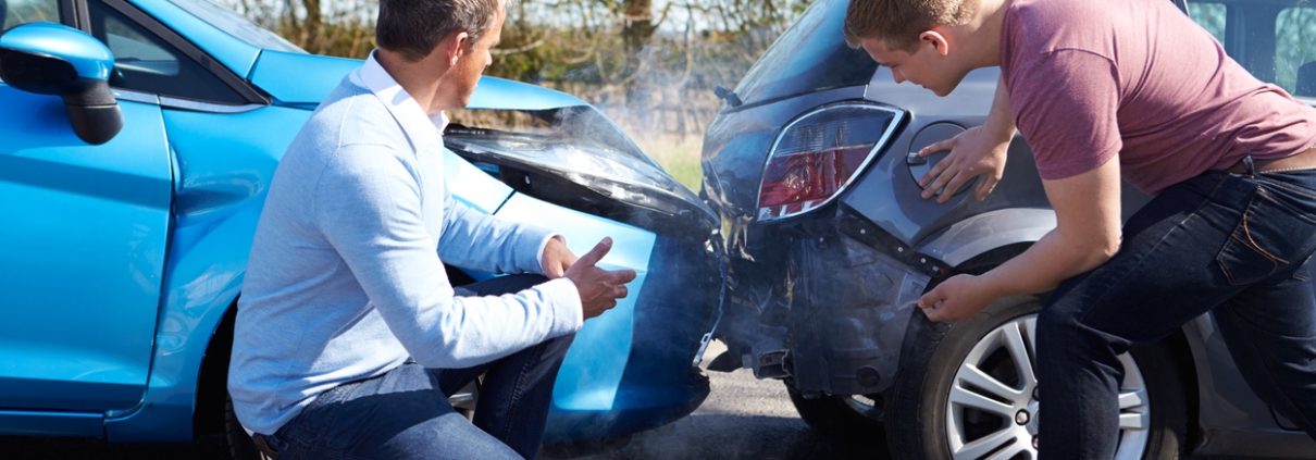 Two Drivers Arguing After Traffic Accident looking at damage