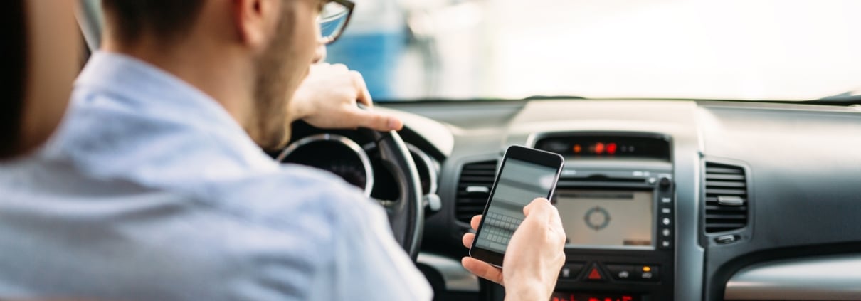 transportation concept - man using phone while driving the car