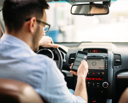 transportation concept - man using phone while driving the car