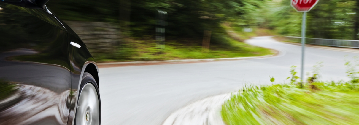 Motion blur of a car speeding towards the junction with Stop sign