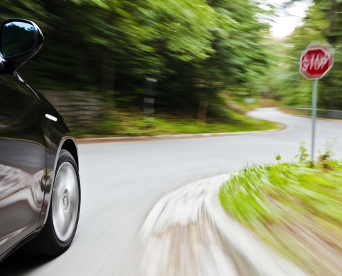 Motion blur of a car speeding towards the junction with Stop sign