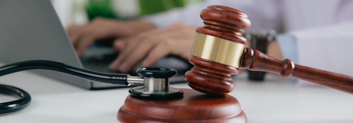 Gavel With Medical Stethoscope while doctor using laptop, Concept of medical law and medical crimes.