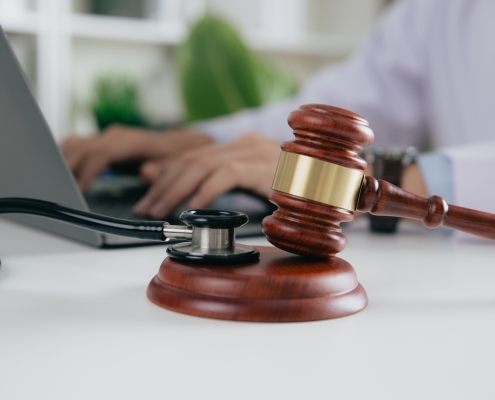 Gavel With Medical Stethoscope while doctor using laptop, Concept of medical law and medical crimes.