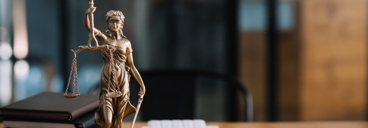 Statue of lady justice on desk of a judge or lawyer.